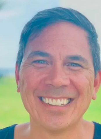 A close up of a man 's face smiling.