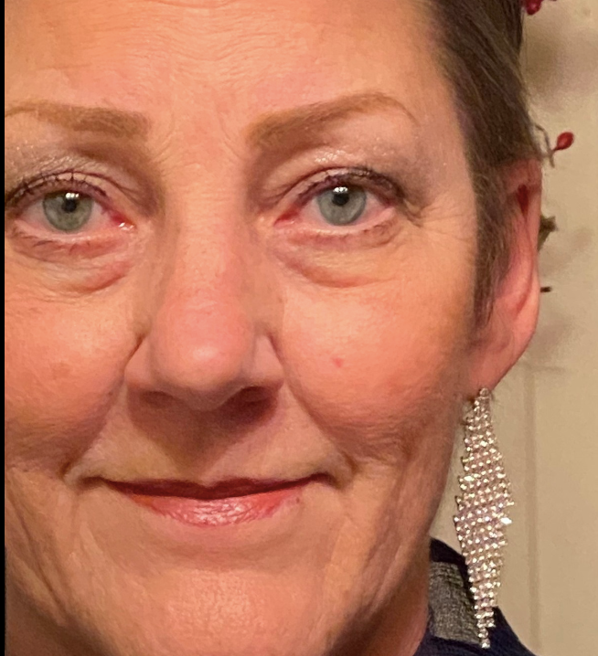 A close up of a woman 's face wearing earrings.