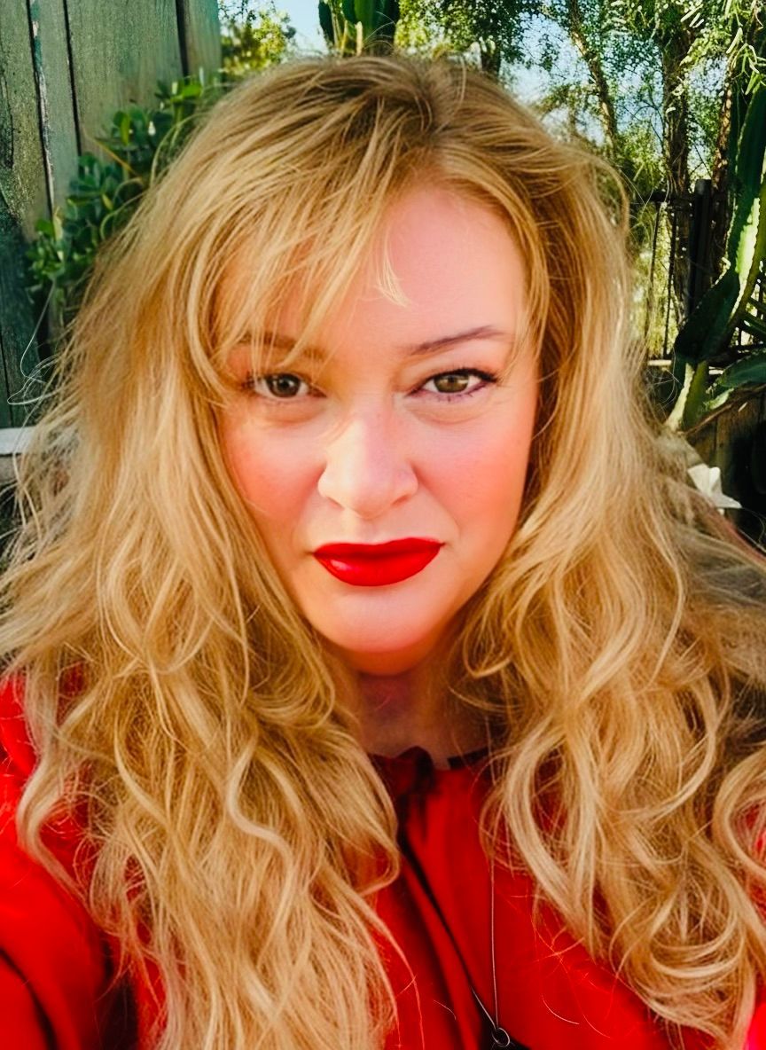 A close up of a woman 's face with blonde hair and red lipstick.