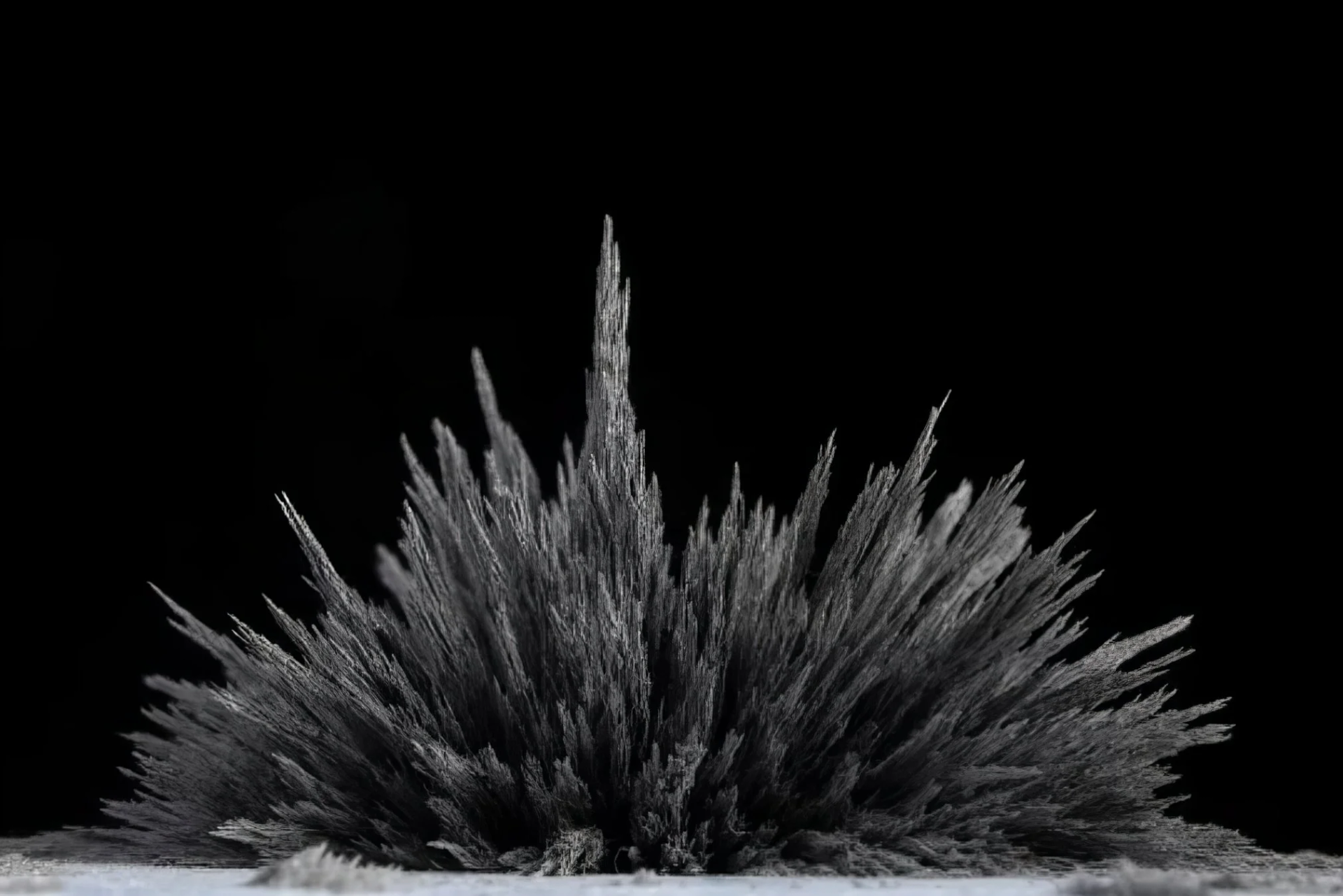 Magnetic filings forming a spiky, starburst-like shape against a black background.