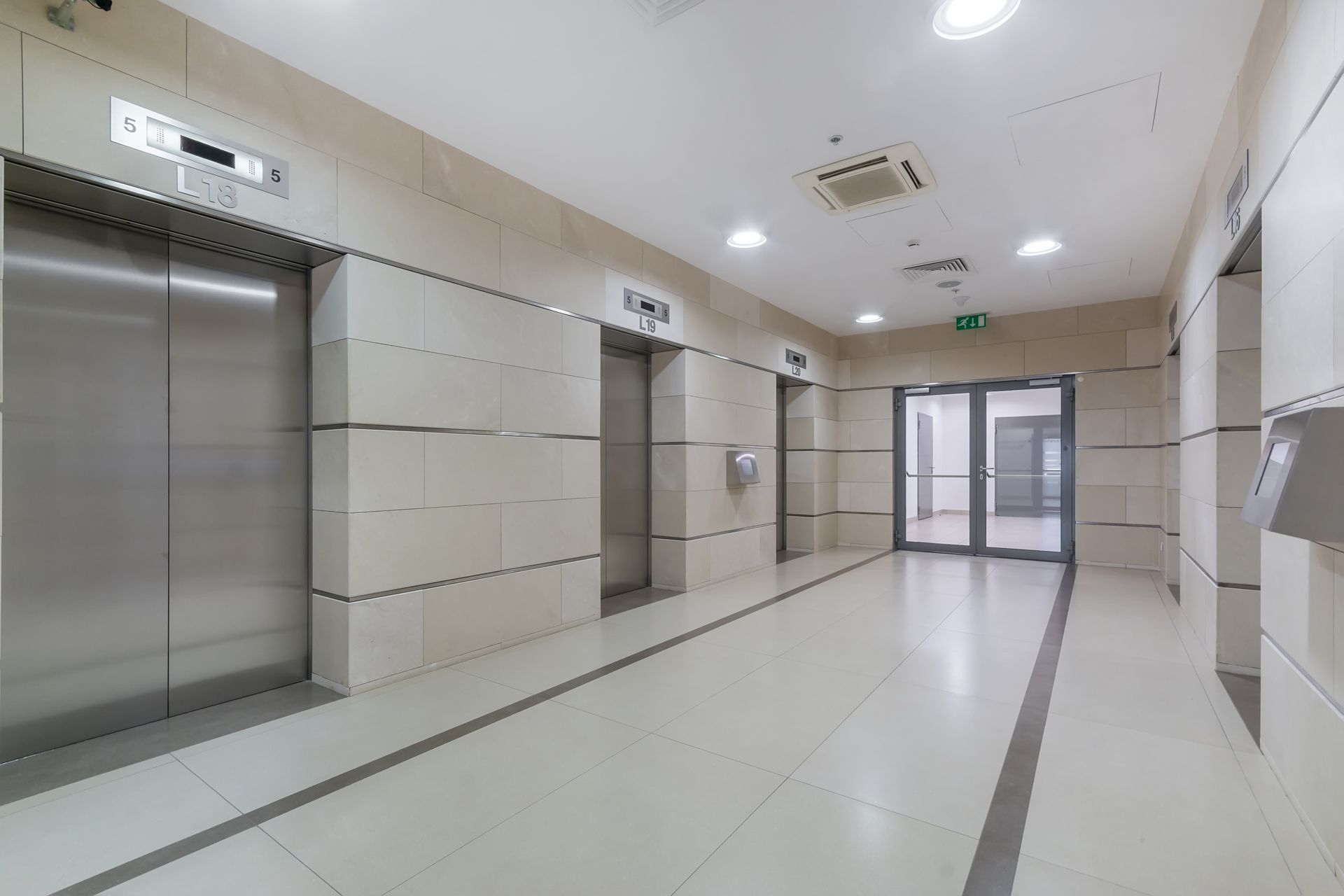 A long hallway with elevators in a building.