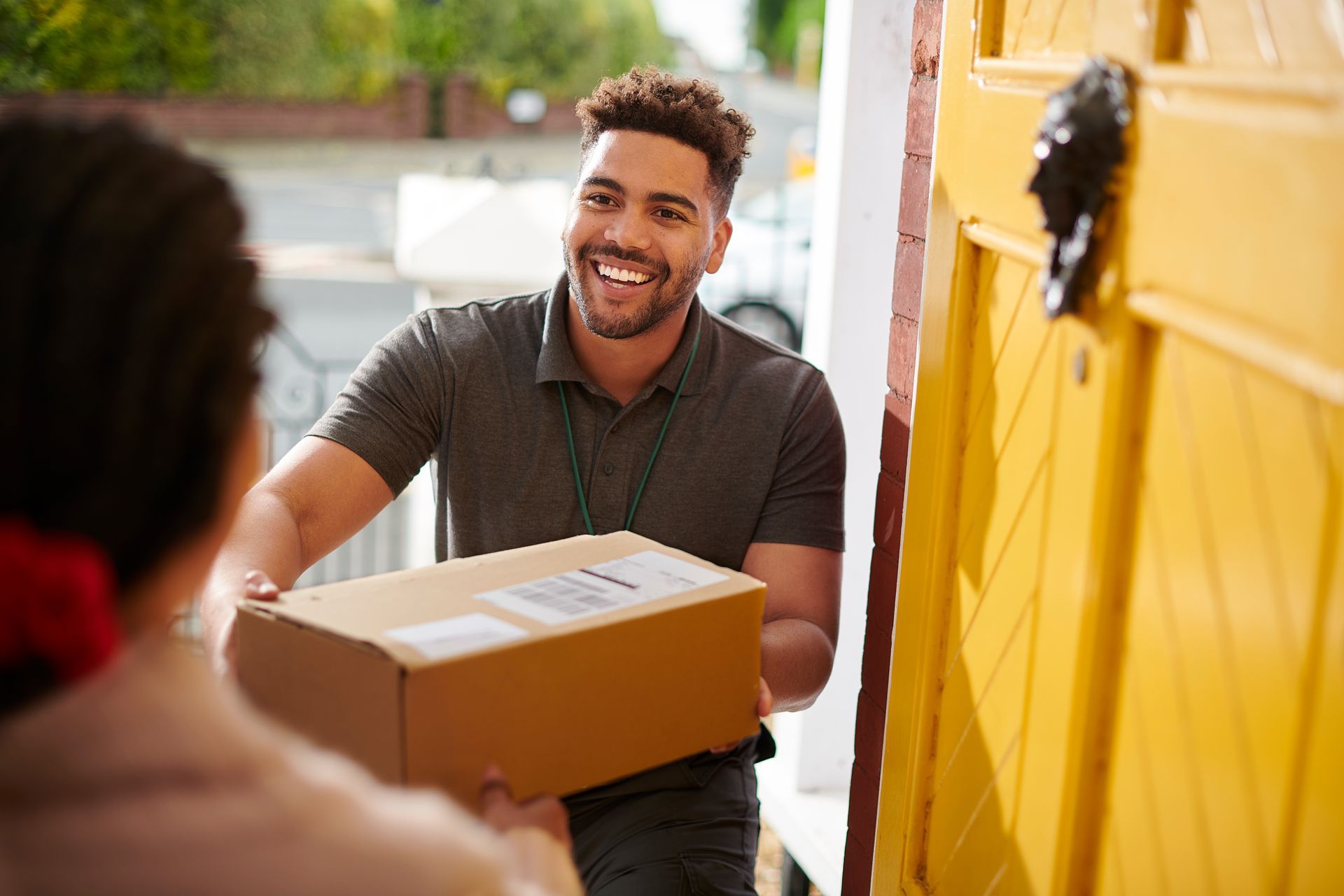 A delivery man is delivering a package to a woman. A delivery man is delivering a package to a woman.