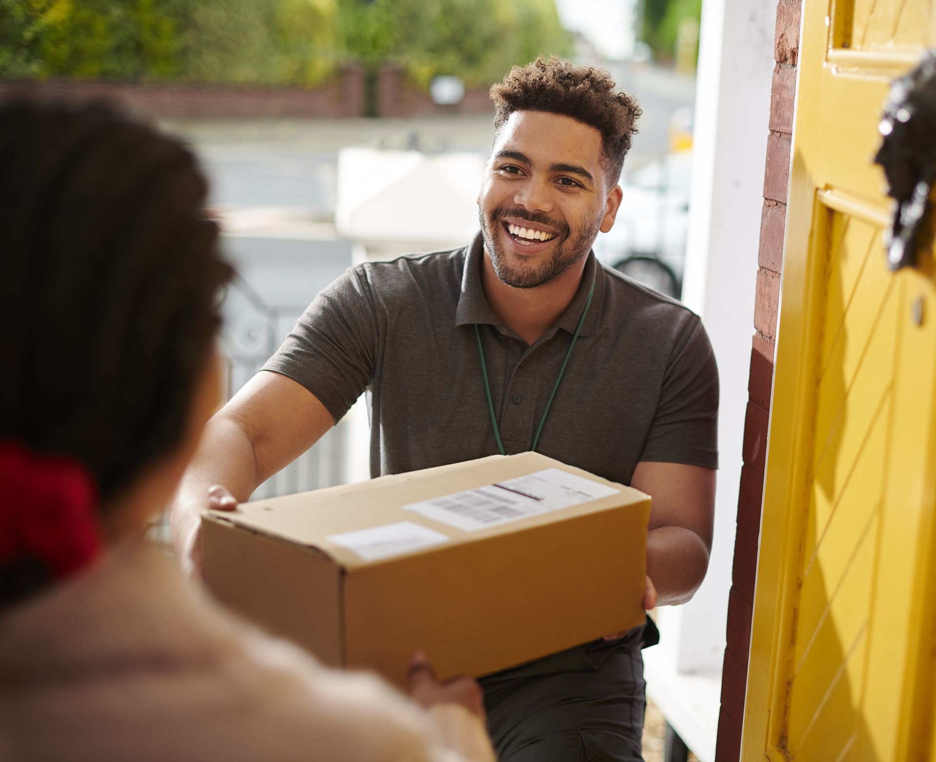 A delivery man is delivering a package to a woman. A man is delivering a package to a woman in a doorway.