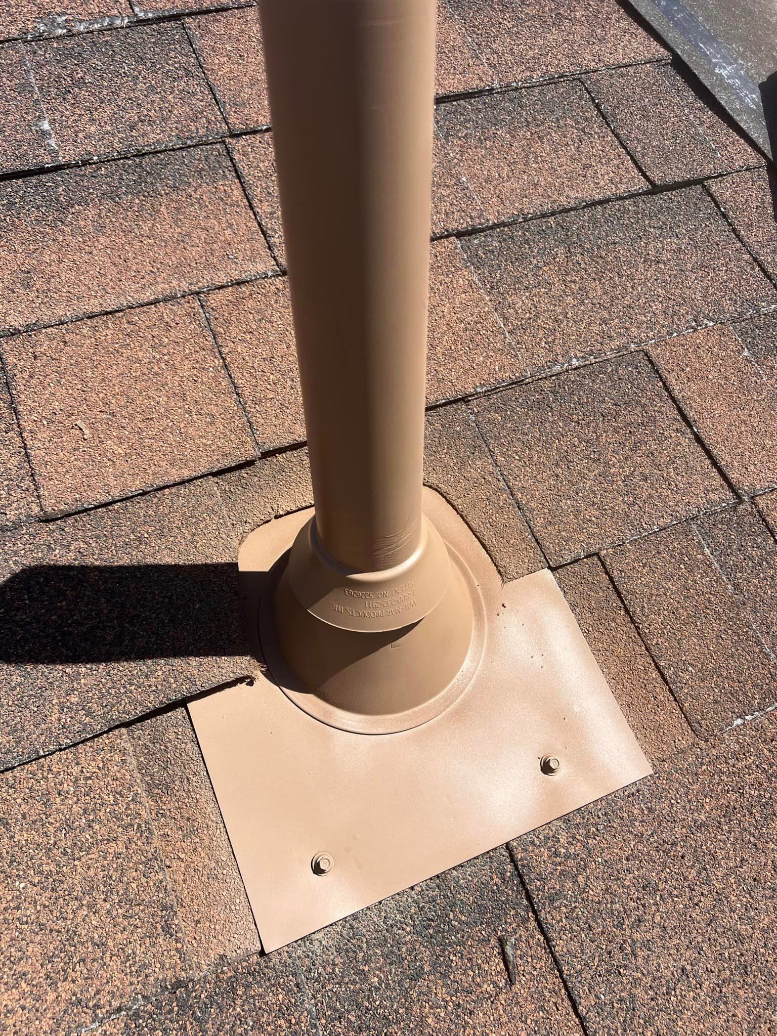 A brown pipe is sitting on top of a brick roof.