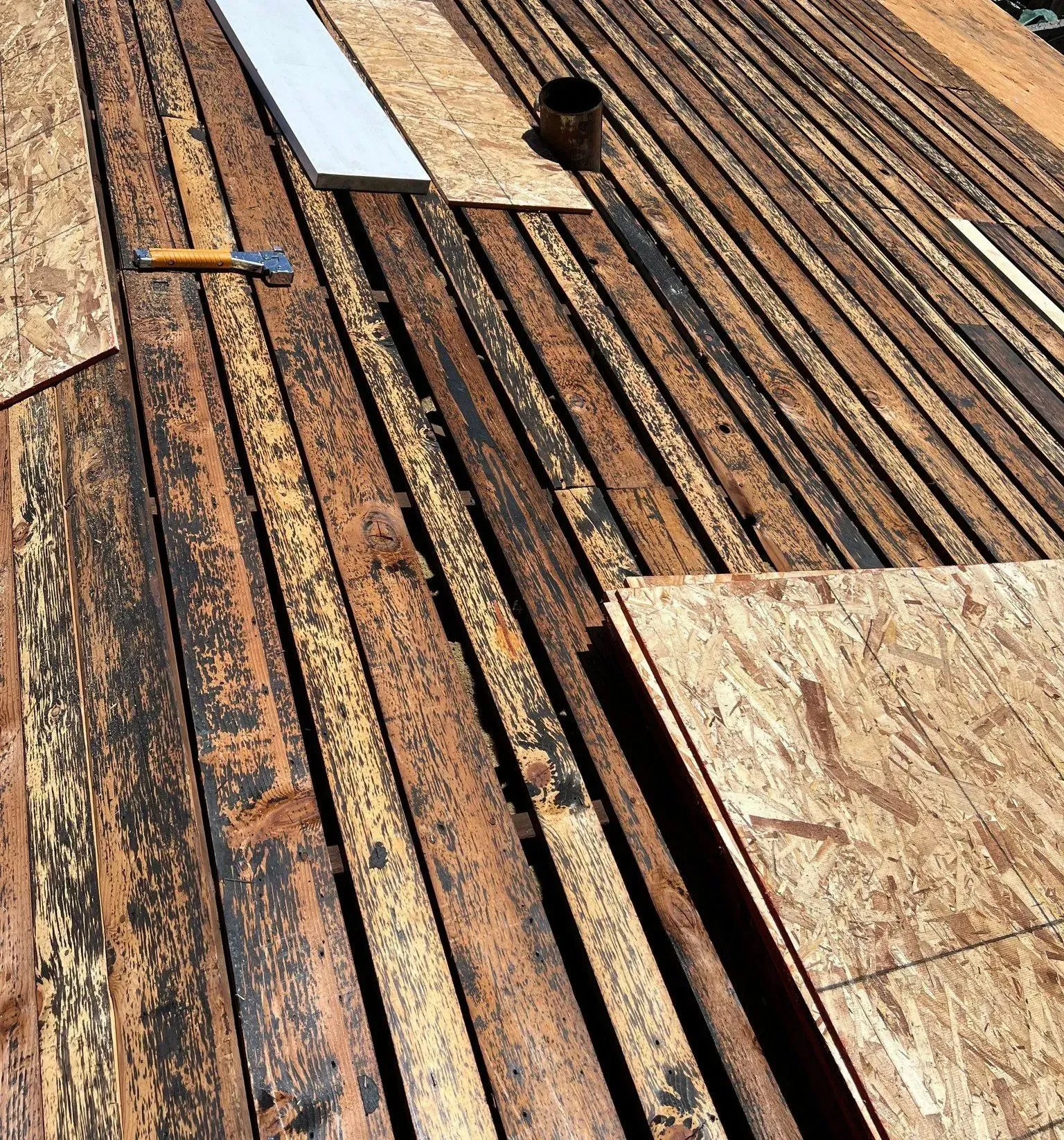 A wooden deck with a hammer and nails on it