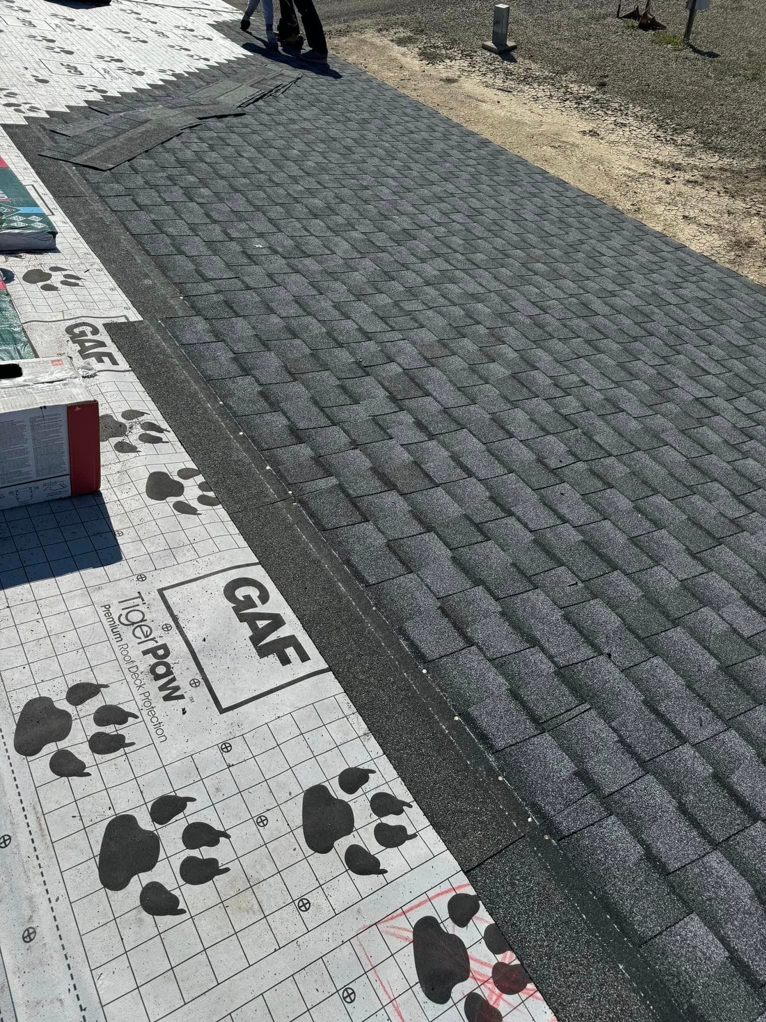 A person is standing on a brick walkway with paw prints on it.