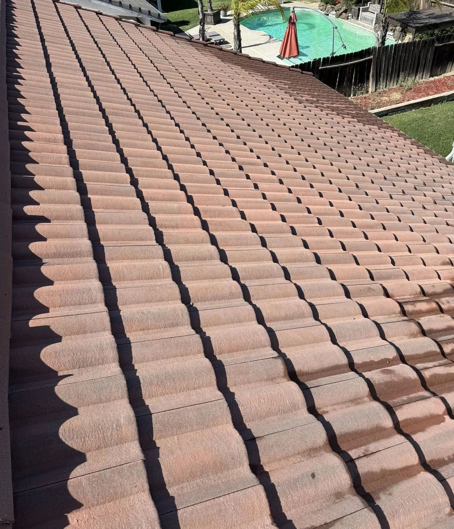 Terracotta-tiled sloped roof with two dark roof valleys, viewed from above