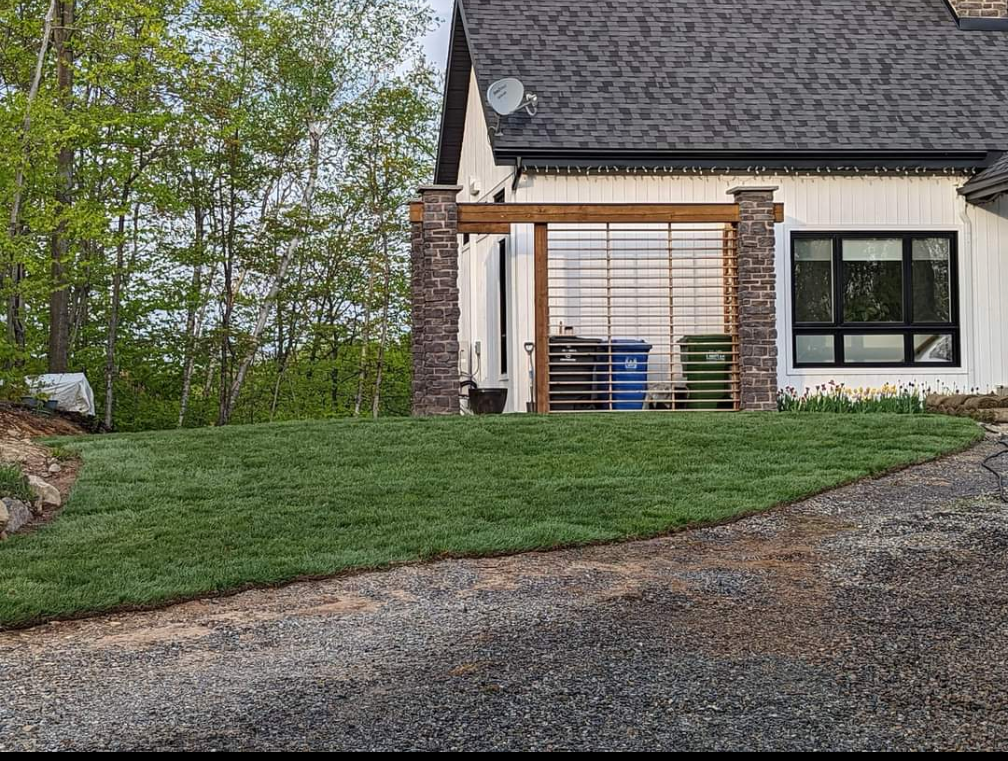 Une maison blanche avec une pelouse verte luxuriante devant elle.