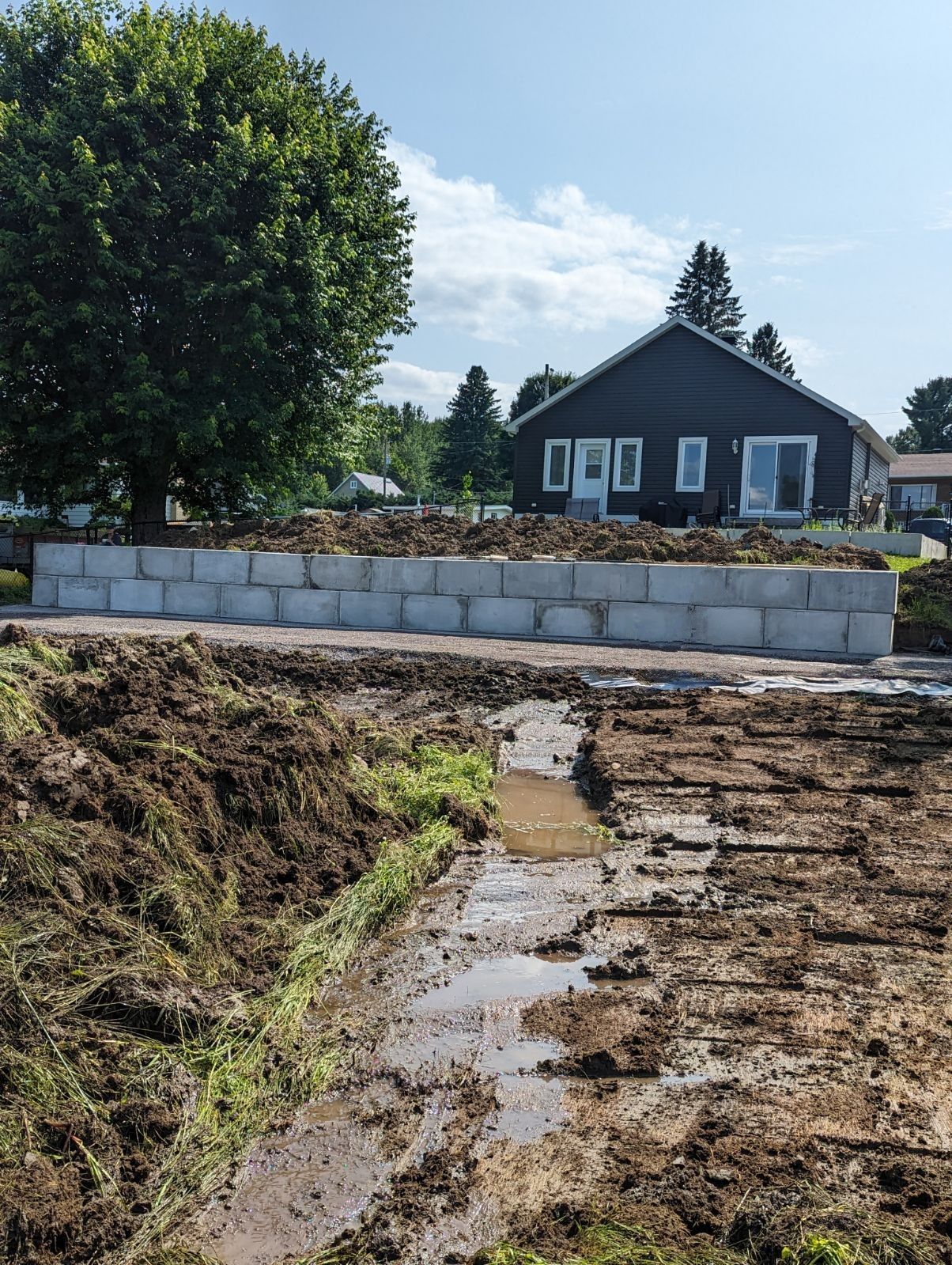 Une maison est en construction au milieu d'un champ boueux.