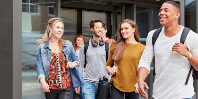 A group of young people are walking in front of a building.