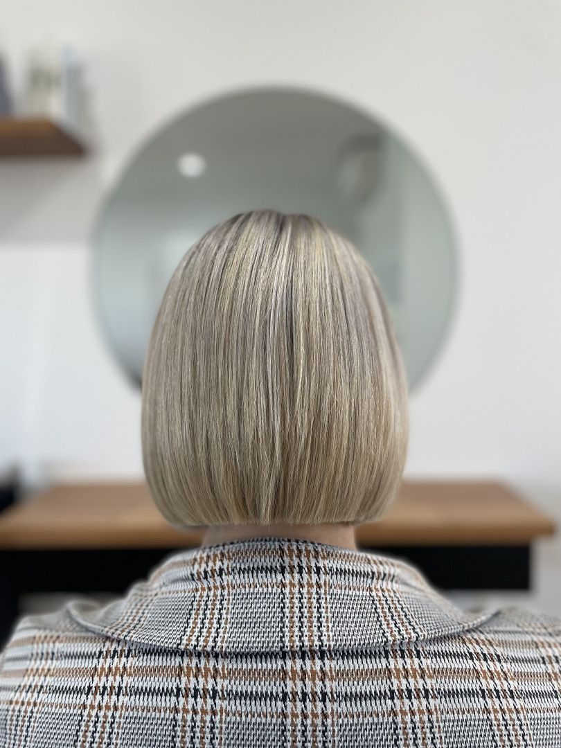 Blonde bob hairstyle, back view, indoors, with a plaid jacket — Clippers Hair Salon in Taree, NSW