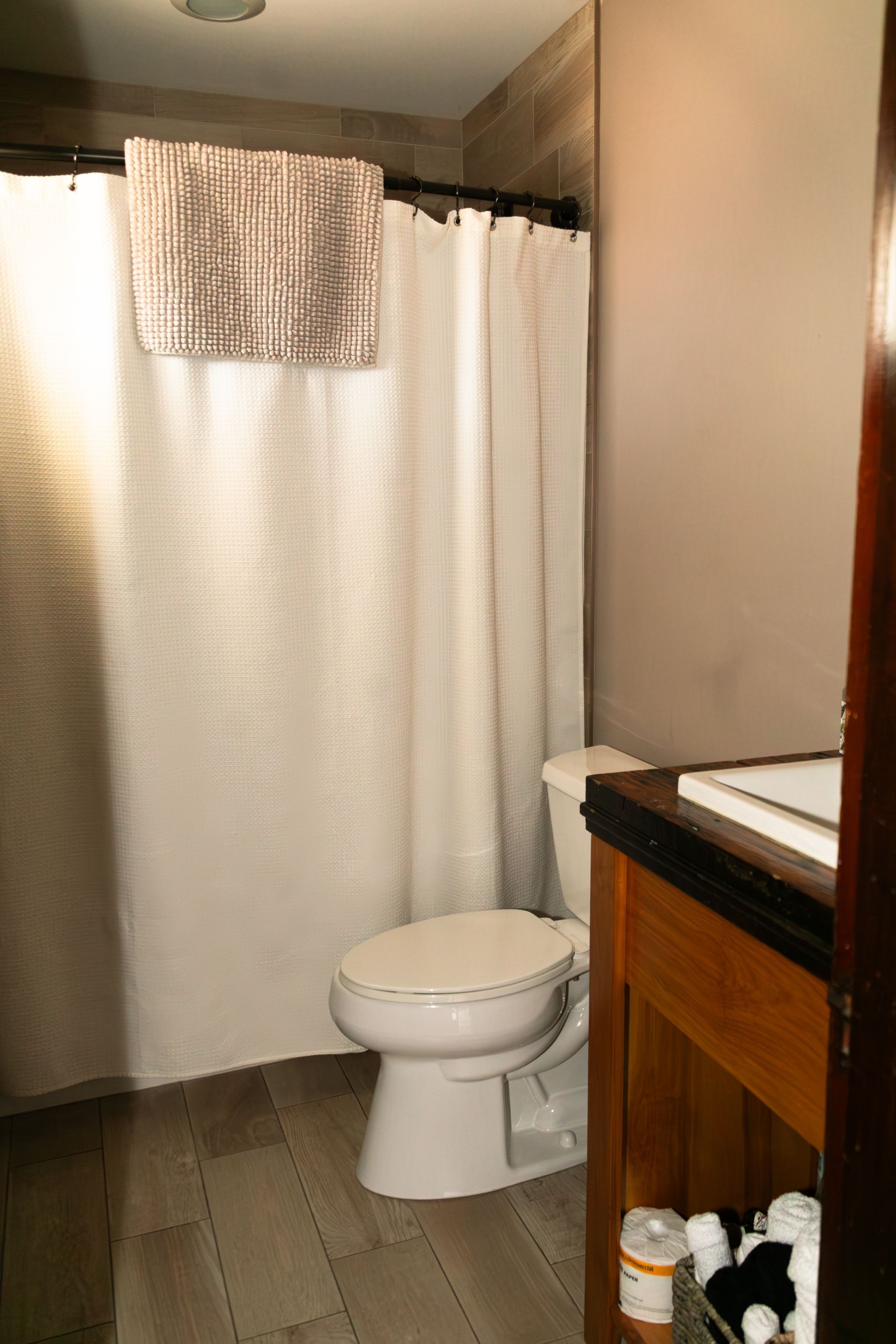 Small bathroom with shower curtain, toilet, and vanity mirror.