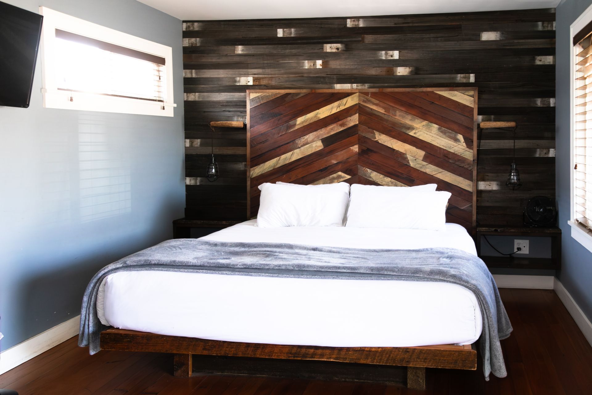 A hotel room with a king size bed and a flat screen tv.