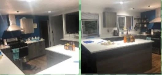 Modern kitchen with dark cabinets, white island countertop, and stainless steel appliances at night