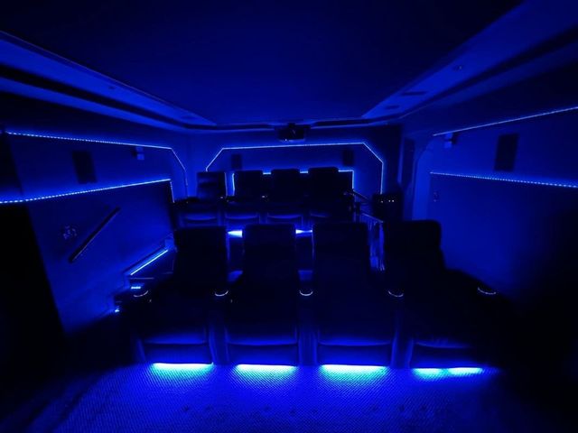 Blue-lit modern lounge with rows of seats and glowing floor lights