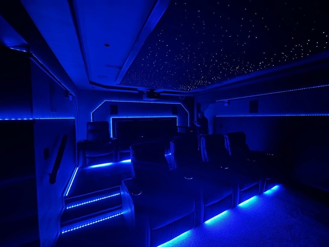 Blue-lit modern lounge interior with steps, seating, and a starry ceiling.