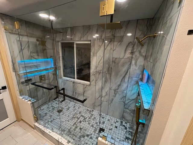 Modern bathroom with white vanity, mirror, toilet, and large marble-look shower stall