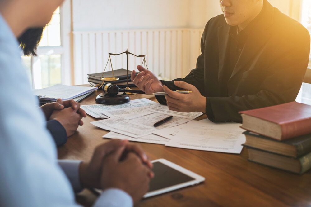 A Group of People Are Sitting at A Table Talking to Each Other — Linda Emery & Associates In Gosford, NSW