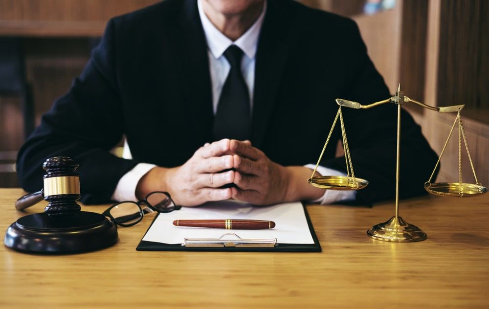 A Judge Is Sitting at A Table with A Gavel and Scales of Justice — Linda Emery & Associates In Gosford, NSW