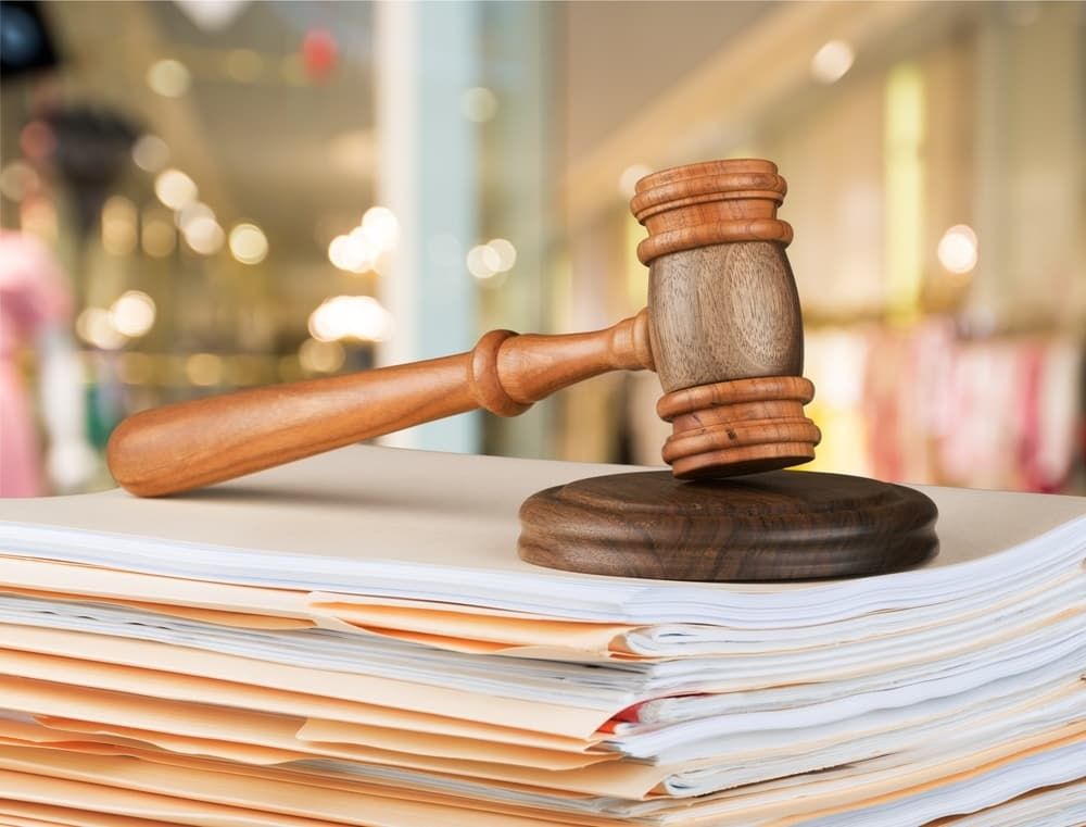 A Wooden Judge 's Gavel Is Sitting on Top of A Stack of Papers — Linda Emery & Associates In Gosford, NSW