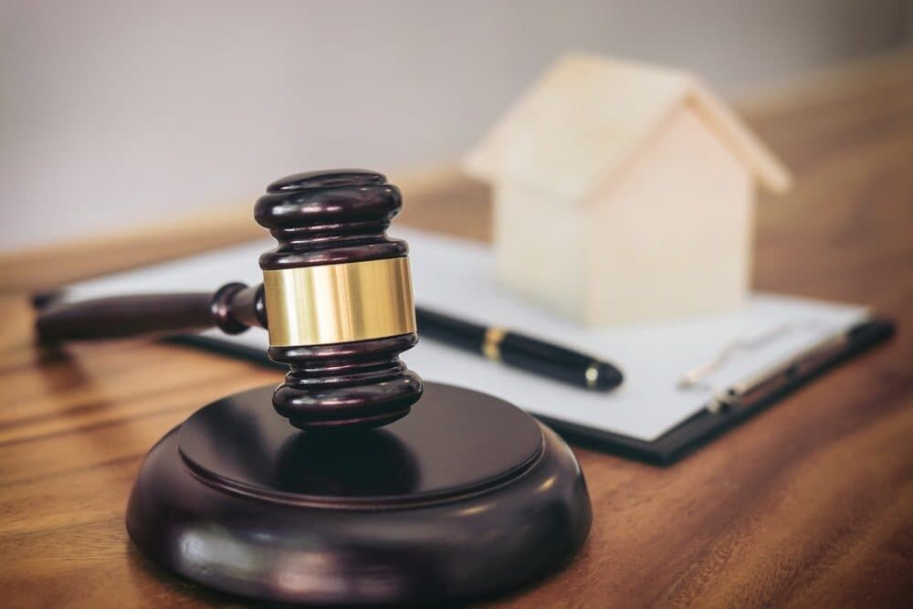 A Judge 's Gavel Is Sitting on A Wooden Table Next to A Clipboard and Pen — Linda Emery & Associates In Gosford, NSW