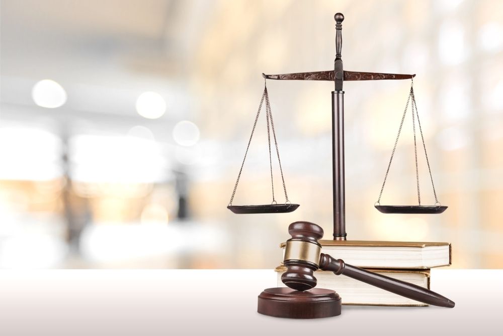 A Scale of Justice and A Judge 's Gavel Are on A Table — Linda Emery & Associates In Gosford, NSW