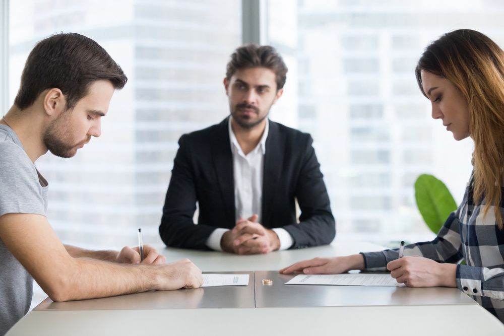 Parents Signing Documents in Front of Family Lawyer