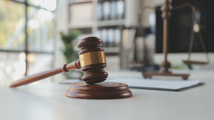 A Wooden Judge 's Gavel Is Sitting on A Table in A Courtroom — Linda Emery & Associates In Bateau Bay, NSW