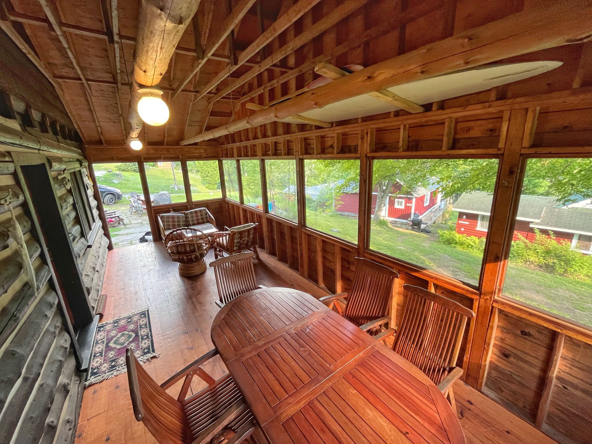 A screened in porch with a table and chairs.