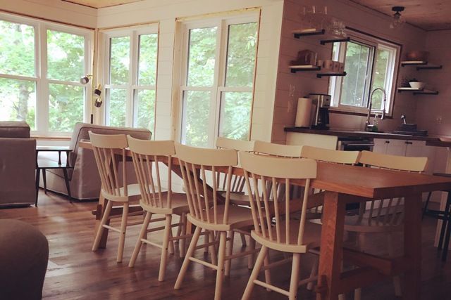 A dining room with a long table and chairs