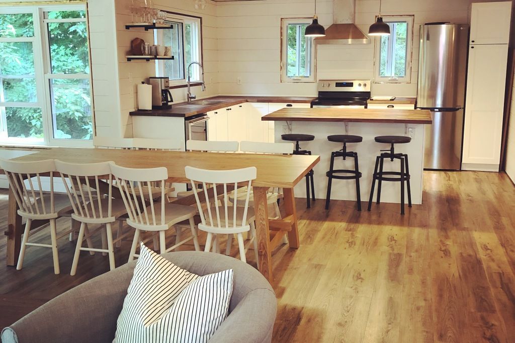A kitchen with a table and chairs and a stainless steel refrigerator