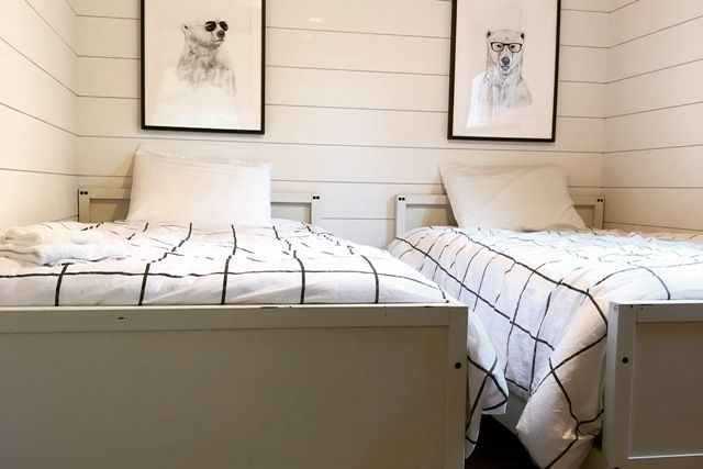 A bedroom with two twin beds and two polar bear paintings on the wall.