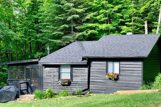 A red house with a grill in front of it