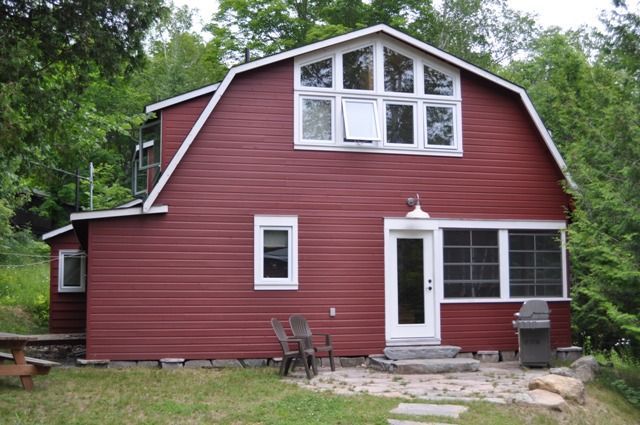 A red barn shaped house with a white door