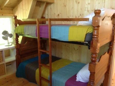A room with bunk beds and a fan in it
