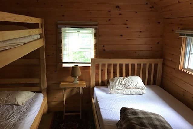 A bedroom with two bunk beds and a window.