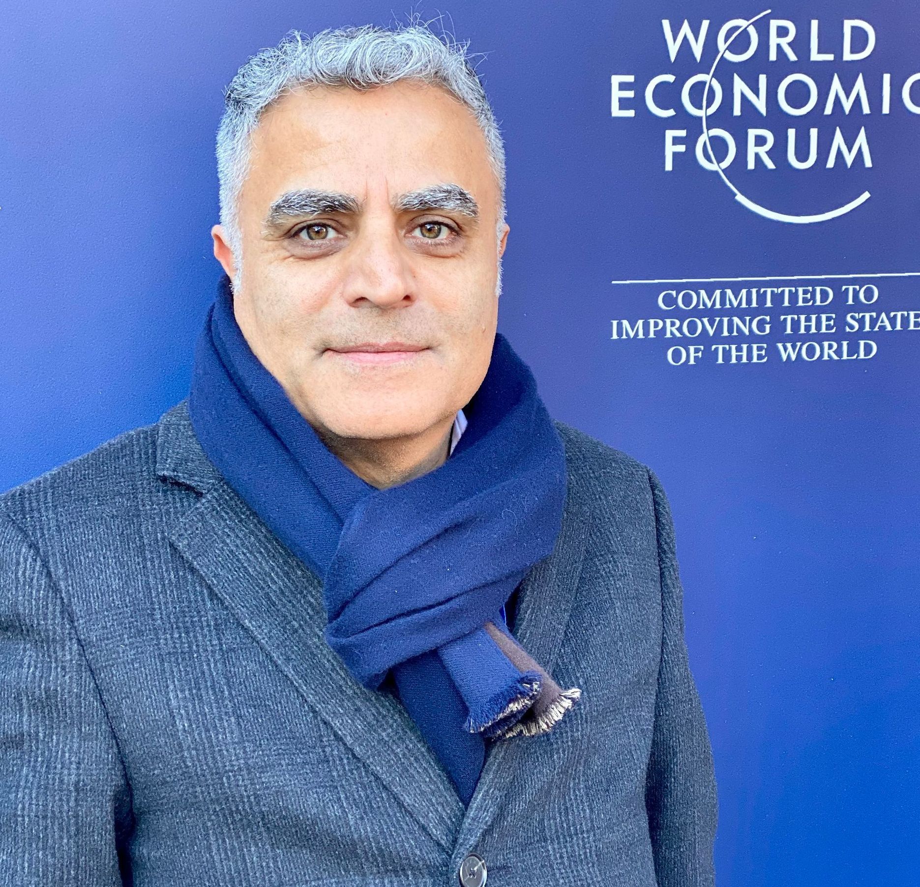 Mike Moghaddas  is standing in front of a world economic forum sign
