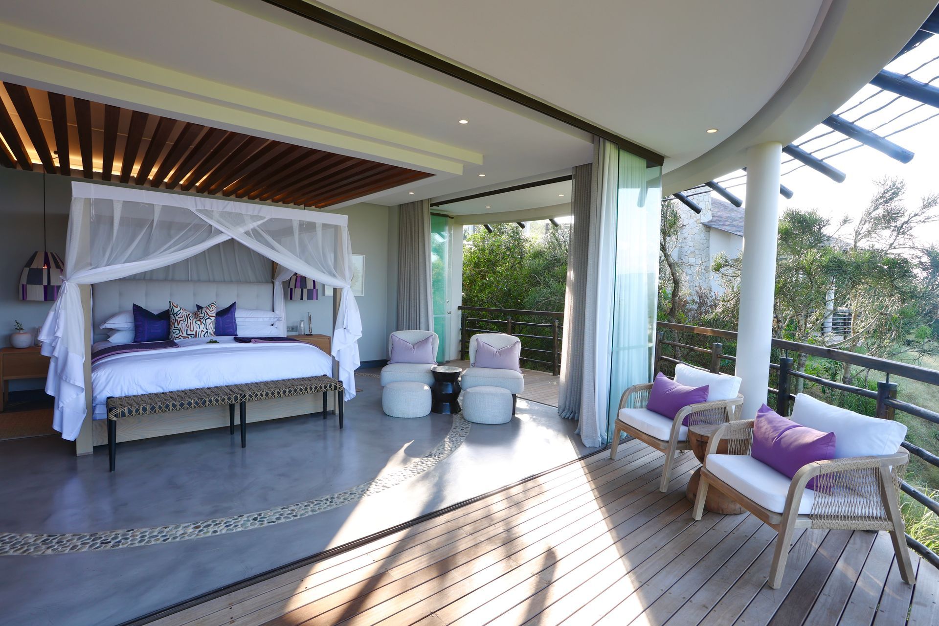 A bedroom with a canopy bed and a balcony