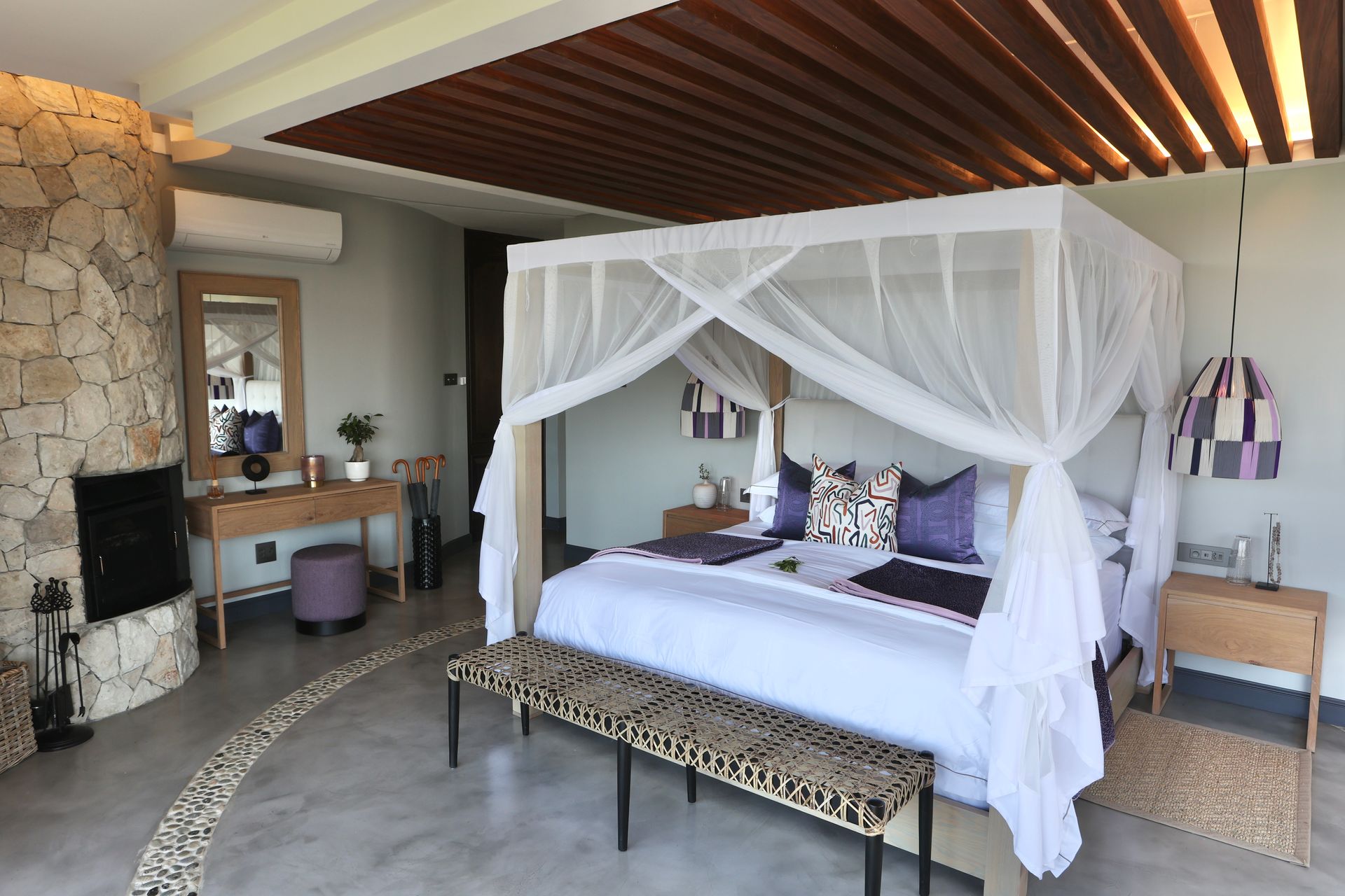 A bedroom with a canopy bed and a bench