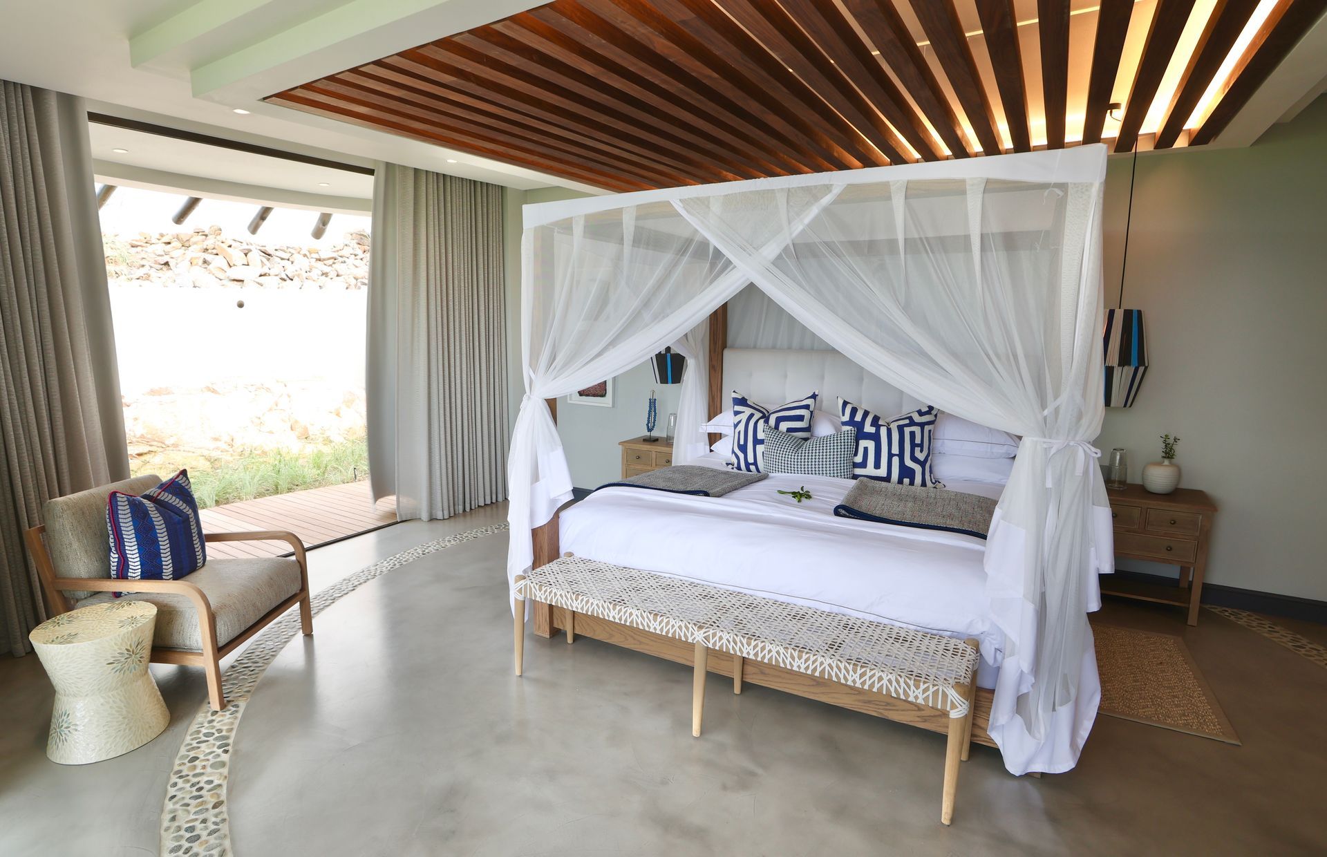A bedroom with a canopy bed and a chair
