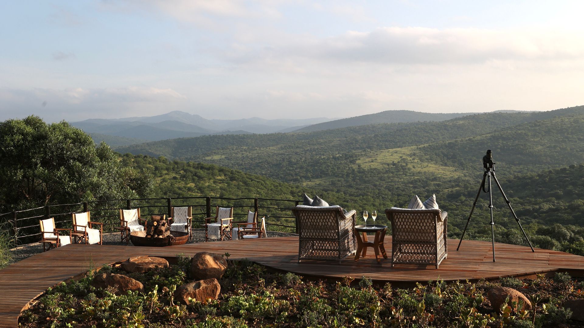 A table and chairs on a deck overlooking a valley
