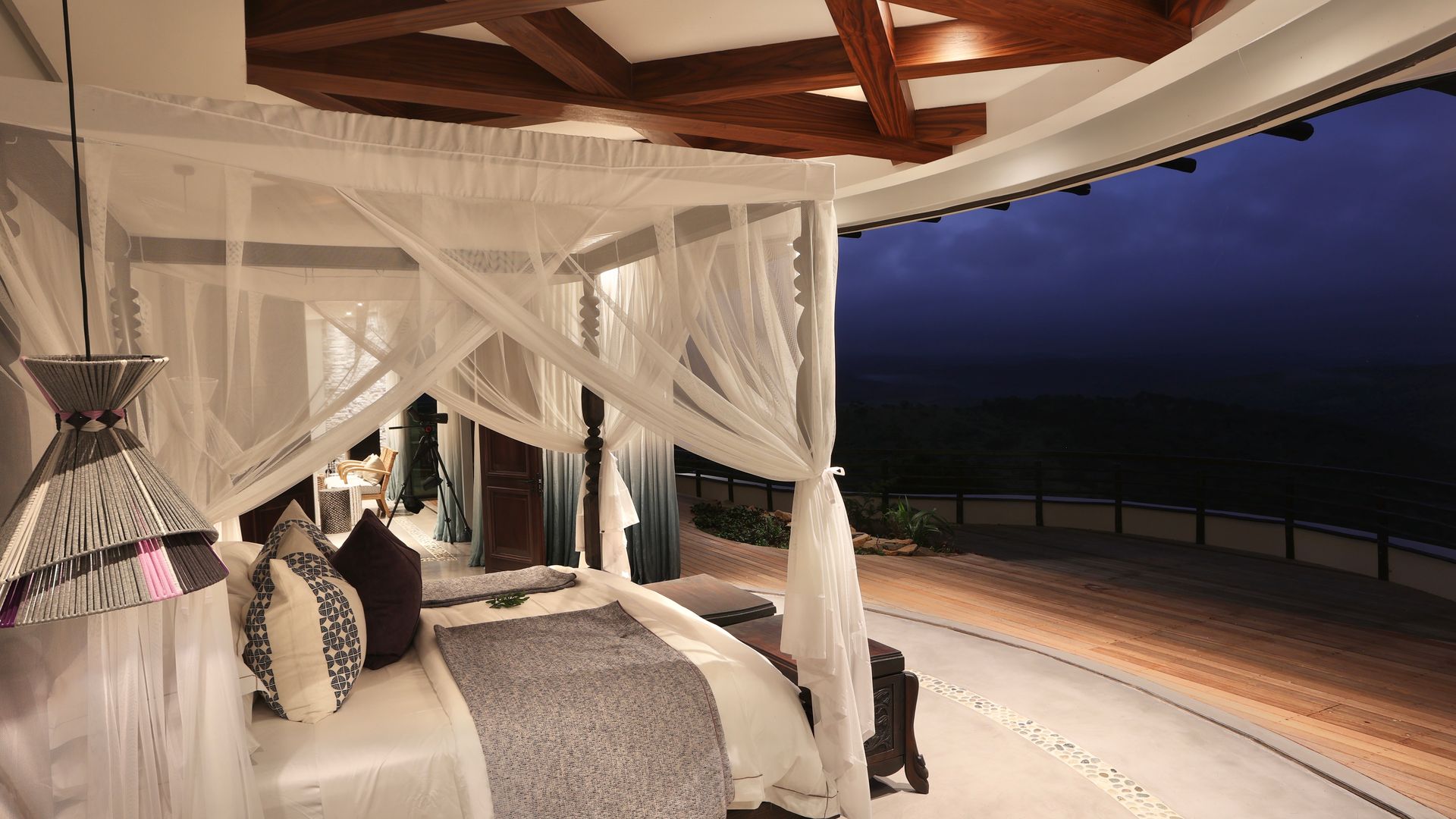 A bedroom with a canopy bed and a view of the ocean.