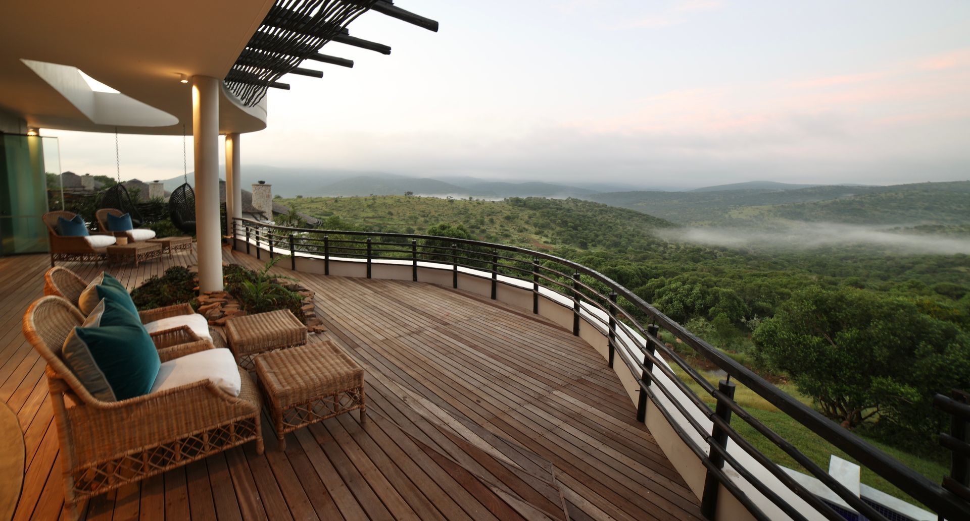 A balcony with a view of a lush green forest