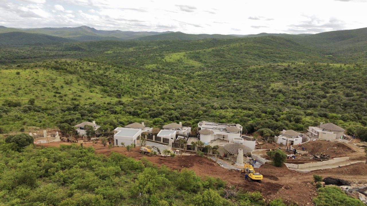 An aerial view of a house being built in the middle of a forest.