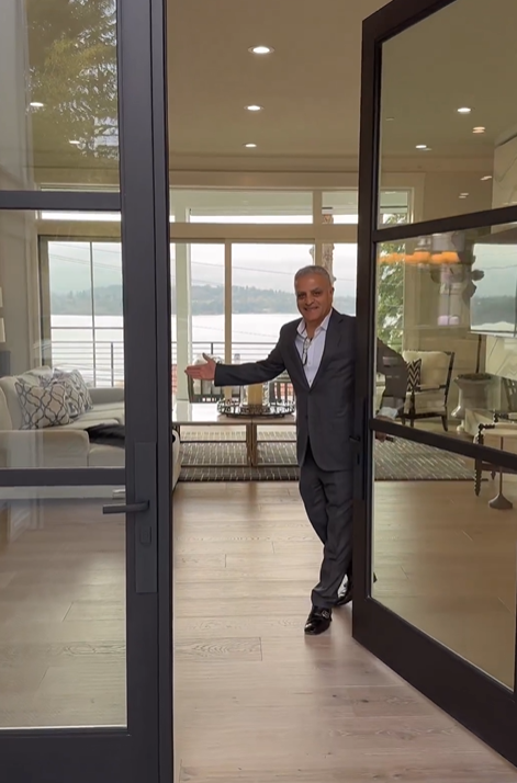 A man in a suit is standing in the doorway of a living room.