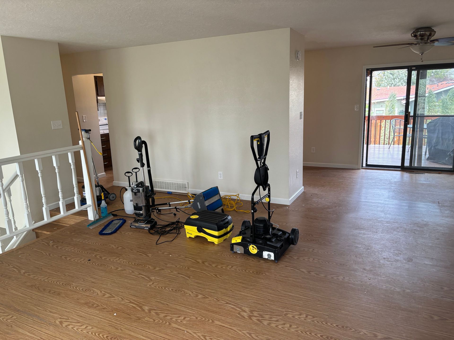 A living room with a vacuum cleaner and a mop on the floor.