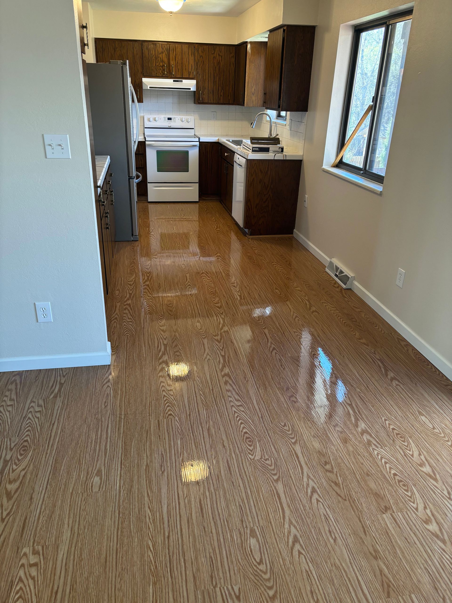 A kitchen with a wooden floor and a stove.
