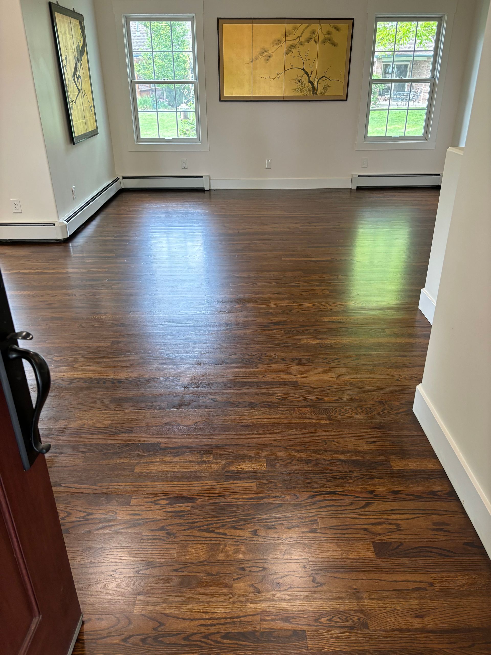 A living room with hardwood floors and a painting on the wall.