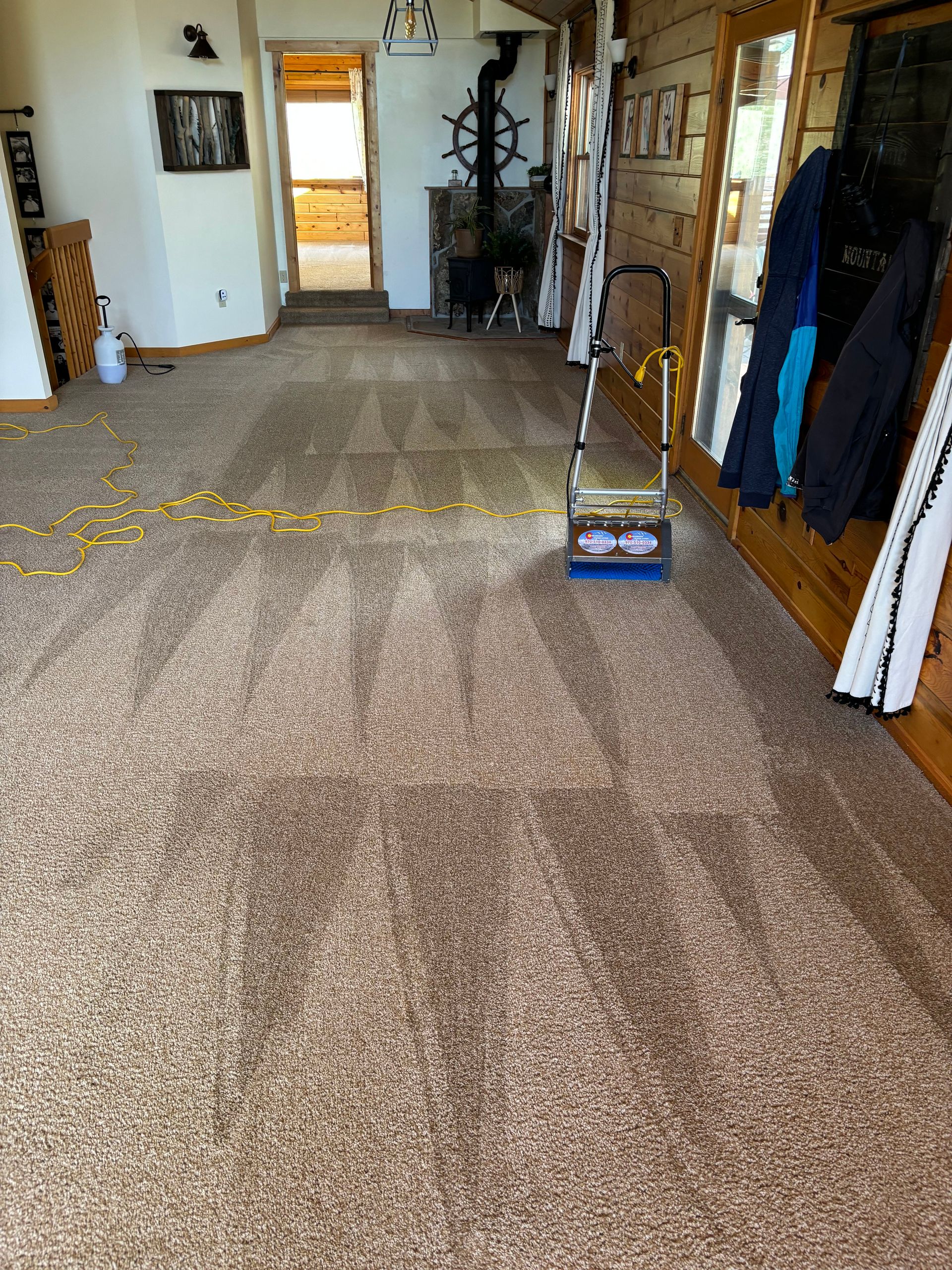 A vacuum cleaner is sitting on a carpeted floor in a living room.