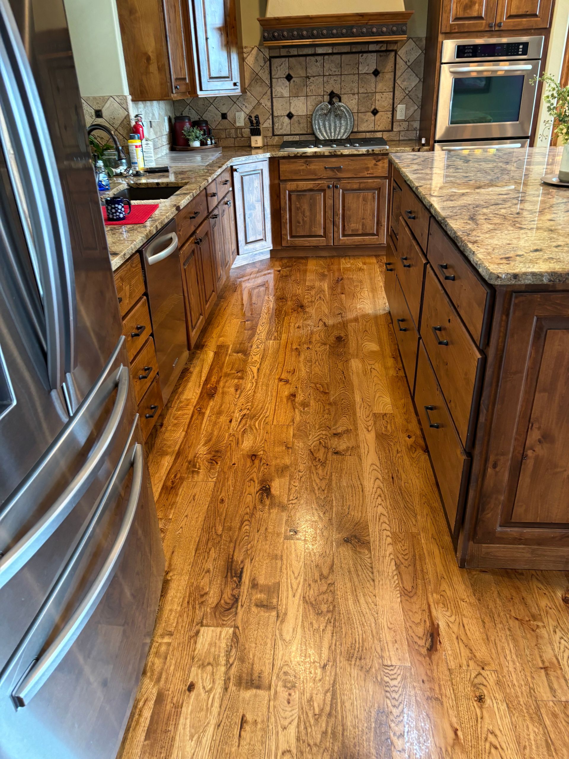 A kitchen with hardwood floors and stainless steel appliances.